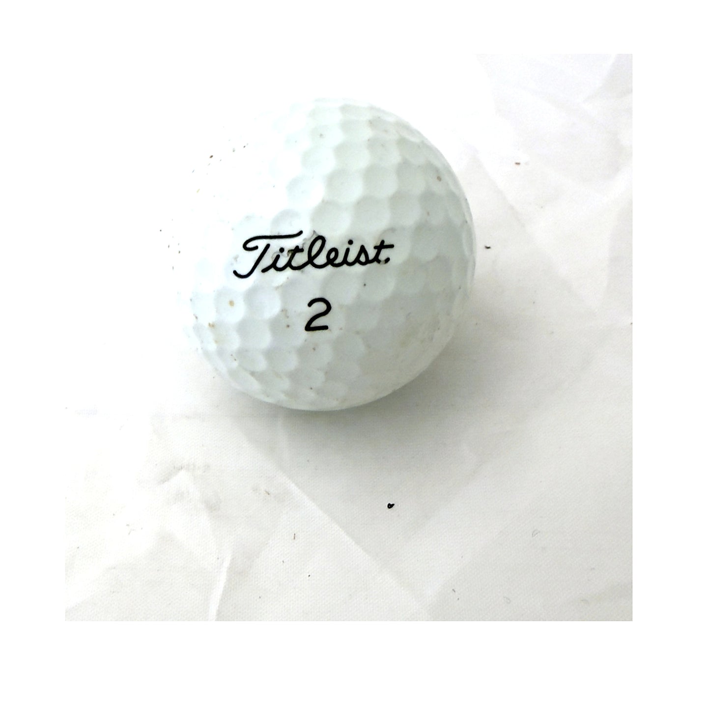 Single used Titleist golf ball, Value (3A) grade, brand side